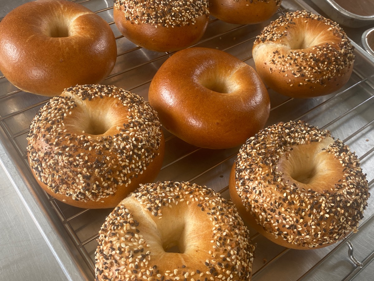 Collection of various artisanal breads including sourdough, buns, and specialty breads